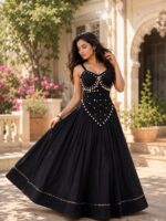 Black pure rayon cotton flare chaniya choli featuring 6m gher skirt with mirror work hemline and a stitched corset-style sleeveless blouse with white cowrie shells.